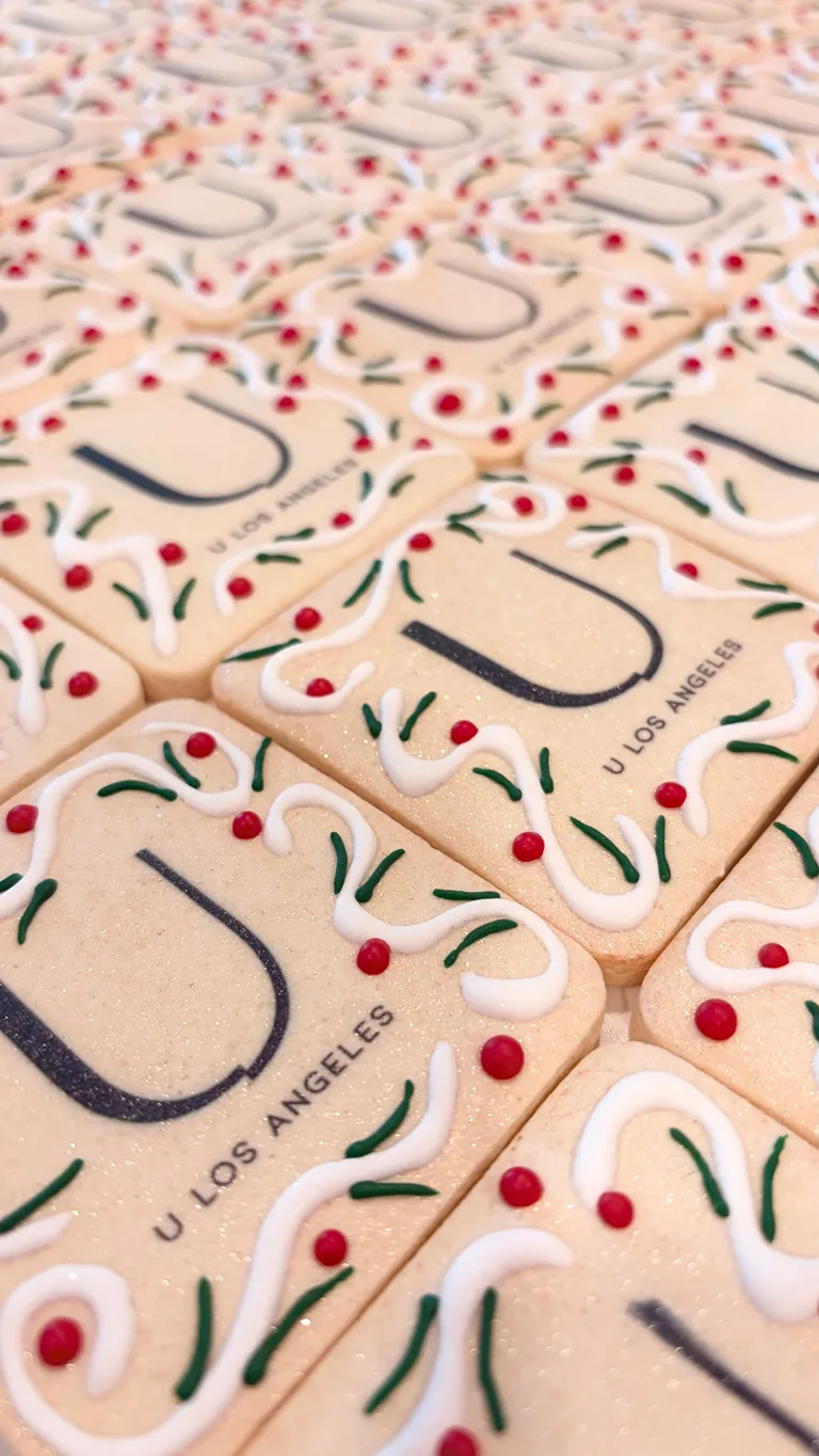 Overhead view of Los Angeles branded items with red cherry patterns and green leaf designs on cream-colored surfaces arranged in rows